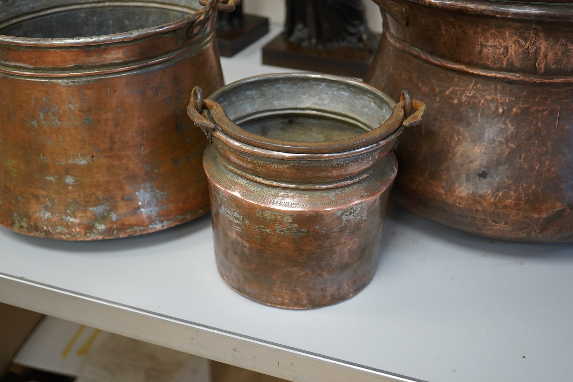 A set of three graduated coppered buckets with swing handles. Largest 22cm high. Condition - fair